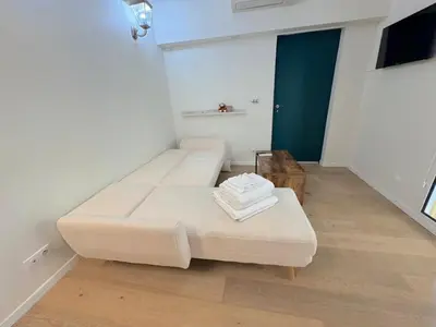 a white room with a couch and a table at ⁂ Charmant Mezzanine Central - Clim Wifi Famille in Nice