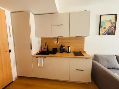 a small kitchen with white cabinets and a couch at Coin d'Amour Gambetta in Nice