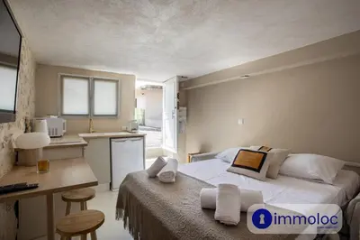 a bedroom with a bed and a desk and a kitchen at Studio in Villefranche in Villefranche-sur-Mer