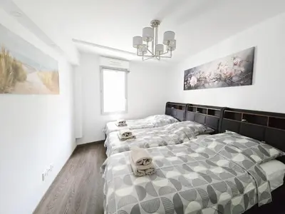 two beds in a room with white walls at Nice Riquier 8 in Nice