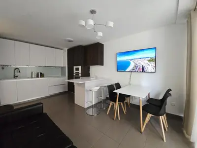 a kitchen with white cabinets and a table and chairs at Nice Riquier 8 in Nice