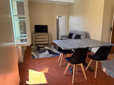 a living room with a wooden table and chairs at STE REPARATE - Cosy 2 pieces vue cathedrale in Nice