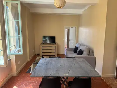 a living room with a table and a couch at STE REPARATE - Cosy 2 pieces vue cathedrale in Nice
