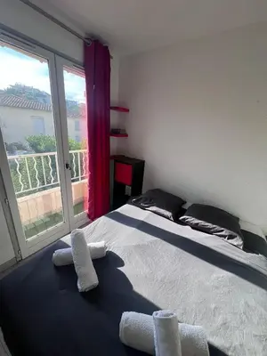 a bedroom with a bed and a large window at Studio à 5min de la plage in Nice