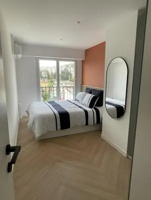 a bedroom with a large bed and a mirror at Azure blue in Nice