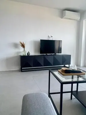 a living room with a tv and a table at Azure blue in Nice