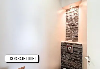 a bathroom with a stone toilet with a stone wall at Nestor&Jeeves - NISSA - Central location in Nice