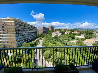 a tall apartment building with cars parked in a park at Nice Ouest-Splendide 3p, Roof-Terrace Panoramic Sea View in Nice