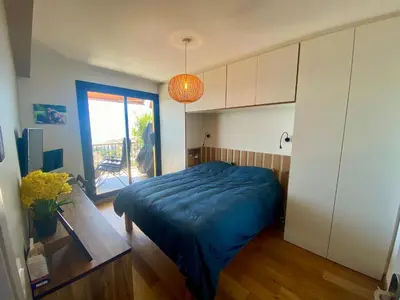 a bedroom with a blue bed and a sliding glass door at Nice Ouest-Splendide 3p, Roof-Terrace Panoramic Sea View in Nice