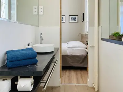 a bathroom with a sink and a bed at Stunning flat with sea view & garden on Promenade dA in Nice