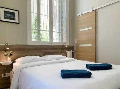 two blue pillows on a white bed in a bedroom at Stunning flat with sea view & garden on Promenade dA in Nice