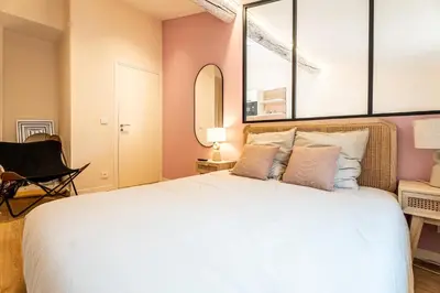 a bedroom with a large bed and a mirror at Le Toit d'Azur in Nice