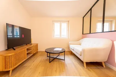 a living room with a white couch and a tv at Le Toit d'Azur in Nice