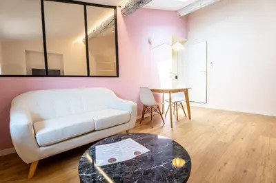 a living room with a white couch and a table at Le Toit d'Azur in Nice