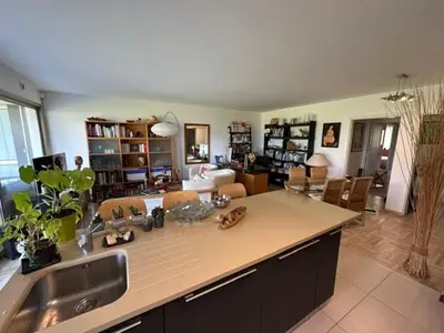 a kitchen with a sink and a living room at Spacieux appartement, Jardin, vue mer, calme in Nice