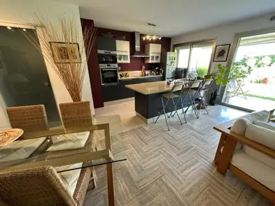 a kitchen and living room with a table and chairs at Spacieux appartement, Jardin, vue mer, calme in Nice