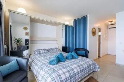 a bedroom with a bed with blue pillows on it at Sea View- Beach- Chic & Air-Conditioned in Saint-Laurent-du-Var