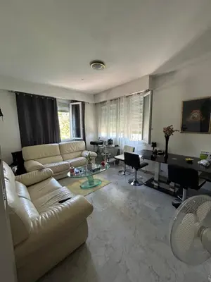 a living room with a white couch and a desk at Appartement Nice promenade des anglais in Nice