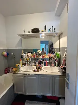 a bathroom with two sinks and a person in a mirror at Appartement Nice promenade des anglais in Nice