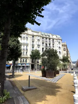 a large white building with trees in front of it at charmant 2 pièces in Nice