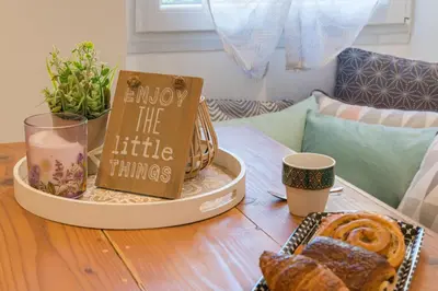 a table with a basket of food and a sign saying enjoy the little things at Le Cocon Niçois in Nice