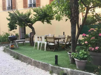 a patio with a table and chairs and trees at Night at La Niçoise - 6 per in Nice