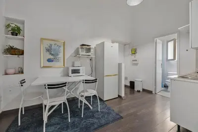a kitchen with a table and chairs and a refrigerator at Nice et confortable 2 pièces cozy in Nice