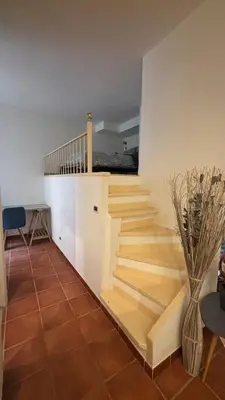 a staircase in a living room with a vase at Studio Carré d 'Or - 5 minutes de la mer in Nice