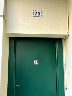 a green door with two numbered signs on it at Cozy apartement near the beach with with Aircon in Nice