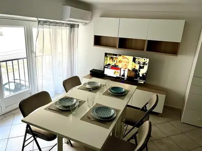 a dining room with a white table and chairs at Cozy apartement near the beach with with Aircon in Nice