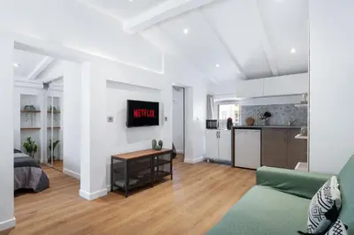 a living room with a couch and a clock on the wall at Nice Renting - 6B FRANCE - Massena beach design AC quiet center wifi in Nice