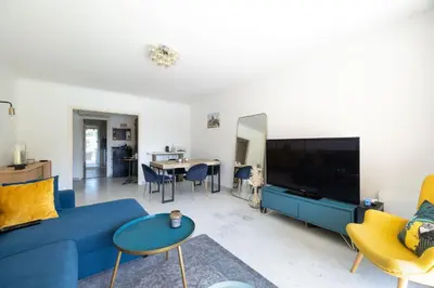 a living room with a blue couch and a tv at Happyfew La Suite Nicerama in Nice
