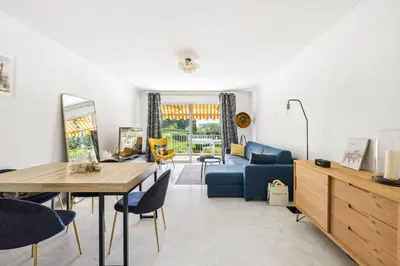 a living room with a table and a blue couch at Happyfew La Suite Nicerama in Nice