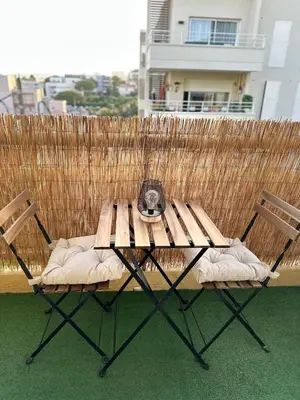 a wooden table and two chairs on a patio at Sun, beach and relaxation in Cagnes-sur-Mer