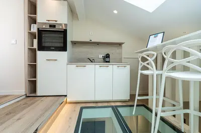 a kitchen with white cabinets and a microwave at La Vila-Vielha in Nice