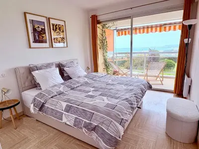 a bedroom with a bed and a large window at Quiet Flat with view and Swimming pool in Nice