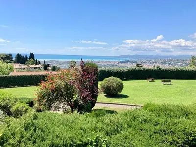 a park with benches and a field of grass at Quiet Flat with view and Swimming pool in Nice