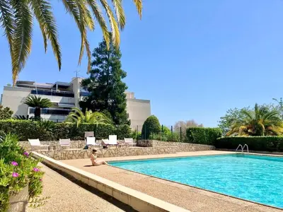 a person sitting in a pool next to a building at Quiet Flat with view and Swimming pool in Nice