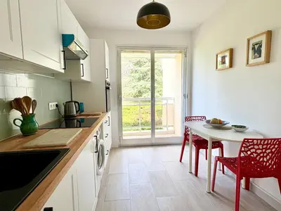 a kitchen with a table and chairs and a window at Quiet Flat with view and Swimming pool in Nice