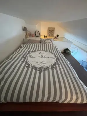 a bed with a black and white striped comforter at Cosy Rooftop Studio Nice Centre in Nice