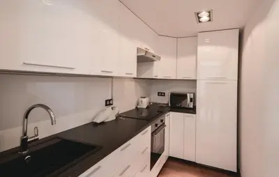 a kitchen with white cabinets and a black counter top at Exceptional Villa with Sea View, Pool & Privacy in Gattières