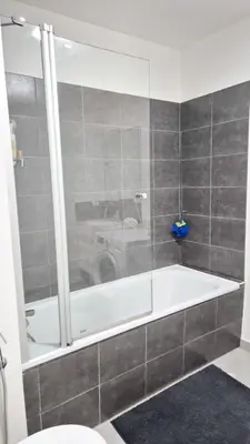 a bathroom with a bath tub and a toilet at T4 avec grande terrasse - BBQ - parking in La Trinité