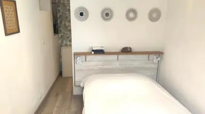 a bedroom with a bed and a table on the wall at Location 2p Nice Centre in Nice