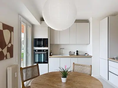 a kitchen with a wooden table and a large light fixture at Azur in Cagnes-sur-Mer