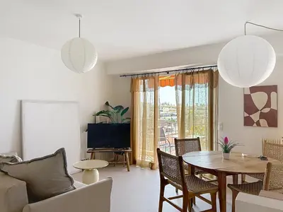 a living room with a table and chairs and a tv at Azur in Cagnes-sur-Mer