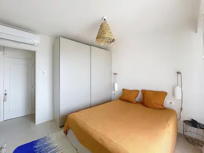 a bedroom with a bed with orange sheets at Azur in Cagnes-sur-Mer