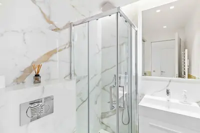 a white bathroom with a shower and a sink at Magnifique appartement avec vue mer époustouflante in Villefranche-sur-Mer