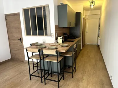 a kitchen with a table and chairs in a room at F1 Cozy, 150m de la mer in Cagnes-sur-Mer