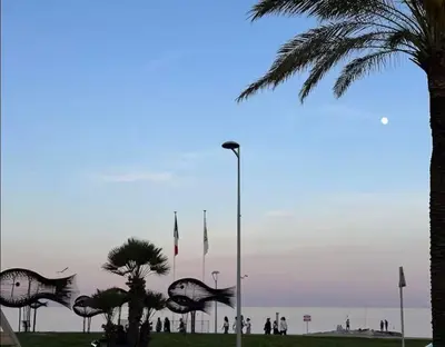 a group of people standing near the beach with flags at F1 Cozy, 150m de la mer in Cagnes-sur-Mer