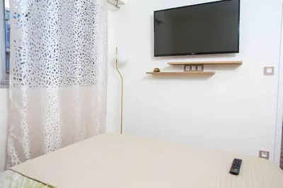 a bedroom with a television and a bed with a remote at Perle de Nice - 50 mètres de la plage, Clim, Wifi in Nice